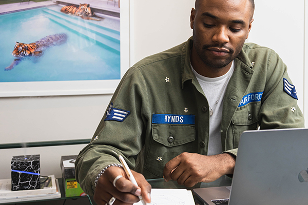 Black military vet in office working in front of desk.